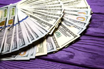 Dollars on a purple wooden background