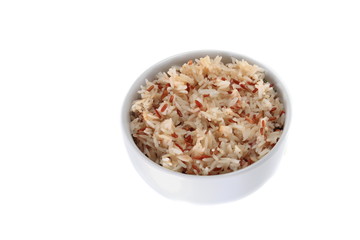 cooked brown rice in cup on white background