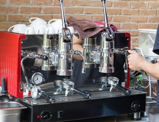 barista brewing hot coffee with coffee machine