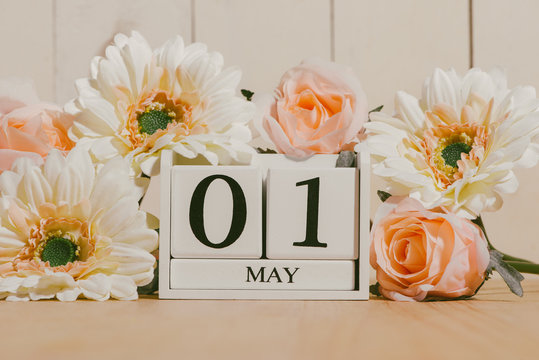 May 1st. Image of may 1 white block calendar on white background with flowers. Spring day, empty space for text. International Workers' Day