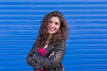 outdoors portrait of a beautiful Young woman over blue background. Casual clothing. lifestyle