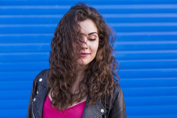 outdoors portrait of a beautiful Young woman over blue background. Casual clothing. lifestyle