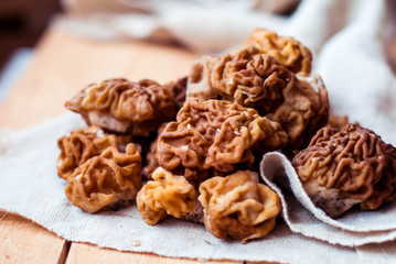 Mushrooms morel on a linen tablecloth and wooden background.