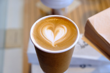 Cup of coffee latte on wooden table in coffee shop