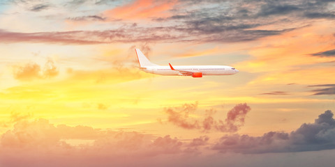 Fototapeta na wymiar Airplane over the clouds in sunset