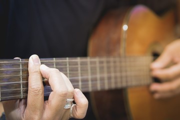 Vintage style closeup acoustic guitar on grunge wooden background