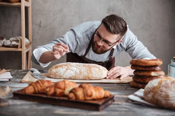 Raamstickers Geconcentreerde mensenbakker die zich bij bakkerij dichtbij brood bevindt. © Drobot Dean