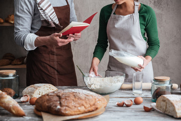 Cropped image of loving couple bakers cooking.