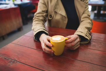 Mug with coffee and hands.