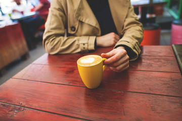 Mug with coffee and hands.