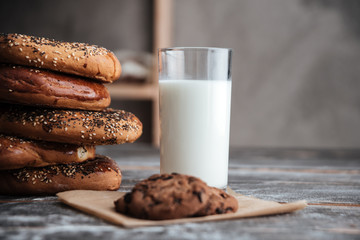 Pastries on dark wooden table with milk and cookie