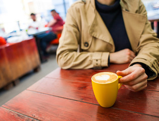 Mug with coffee and hands.