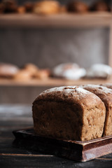 Bread with flour on dark wooden table