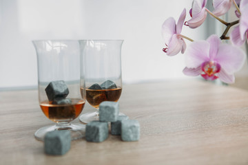 Stones for cooling whiskey and glases tulup on light wooden background