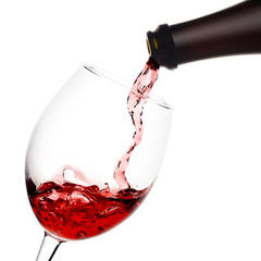 red wine poured from a bottle into wineglass on white background, isolated