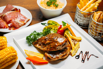 Beef steak with vegetables, corn, rice and fries garnish