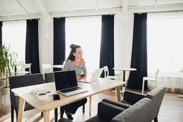 Young attractive woman looking away thoughtfully with her laptop opened.