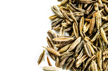 Dry cumin seeds isolated on white. Food background with copy space. Closeup macro shot. Top view.