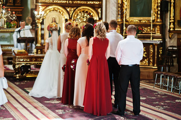 Stylish wedding couple with bridesmaids and best mans at church.
