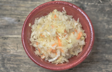 Homemade sauerkraut village. Fermented cabbage. Vegan salad rustic style glass jar or ceramic pottery bowl. Fermented food great for good health. Traditional rustic winter food. Top view.