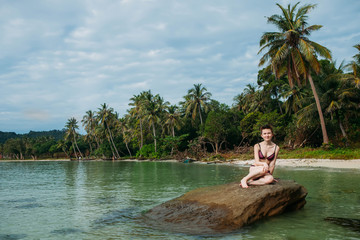 Young caucasian woman sitting on the beach phu quoc