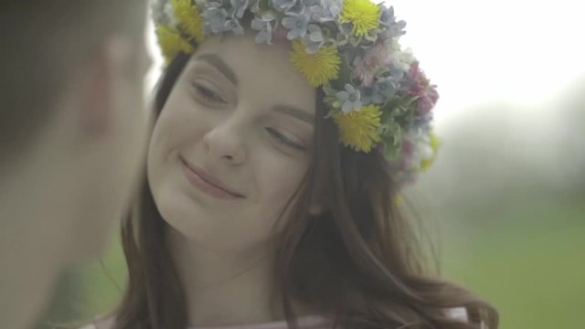 M&auml;dchen mit Blumenkranz schaut Mann verliebt an