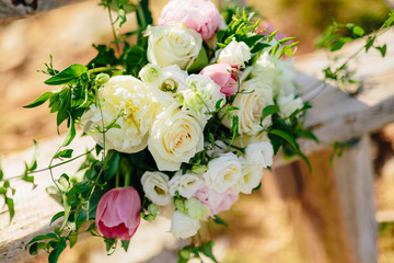 Bridal bouquet of roses and peonis on an old wooden bench handmade. Wedding in Montenegro, Adriatic.