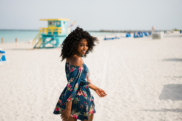 Fashion woman walking on beach with a summer dress