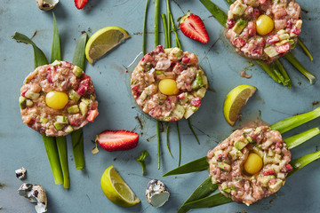 raw meat nests with quail eggs, cucumers and strawberries