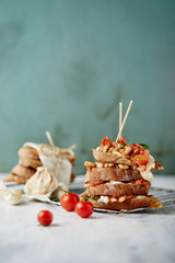 two piles of brown bread sandwiches with tomatoes and shrimps