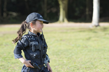 警察の衣装を着てピストルを持った女の子