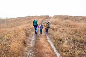 Obraz premium Family with backpacks running on rural path