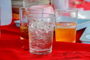 glass of ice are on a table red fabric