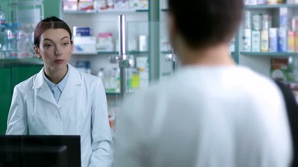 Female pharmacist counseling customer in pharmacy