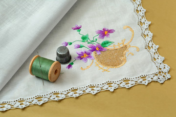 Thread with a needle, a thimble and a handkerchief