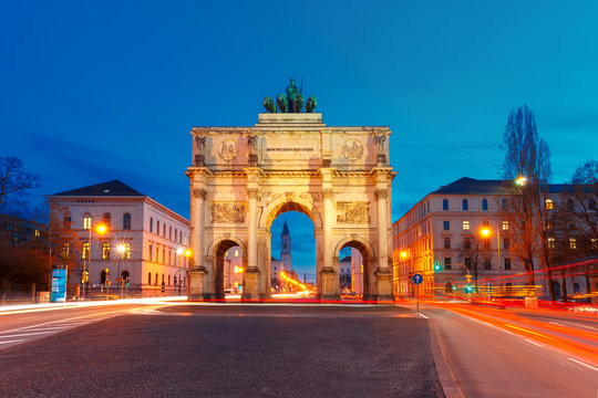 The Siegestor or Victory Gate, triumphal arch crowned with a statue of Bavaria with a lion-quadriga, at night in Munich, Germany