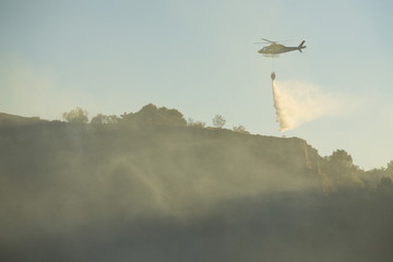 GRANADA, AUGUST 28: Fire fighting Helicopter, with bambi basket, during a fire fighting in the bush. August 28, 2014, Granada, Spain.