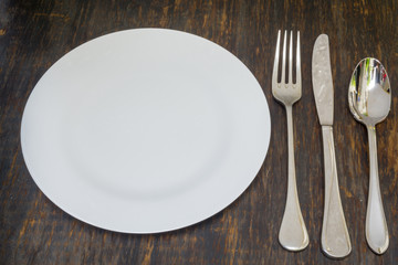 Table setting. Dinner plate, fork, spoon and knife.