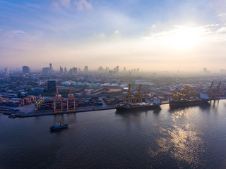 Aerial shot of container ship in dock with beautiful sunlight in the morning