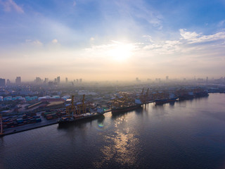 Naklejka premium Aerial shot of container ship in dock with beautiful sunlight in the morning