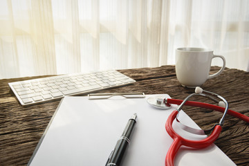 doctor workplace with stethoscope and clipboard at wooden desk