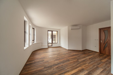 Empty room with natural light from windows.Modern house interior. Wooden floor.