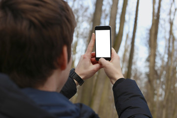 Man takes pictures of the park on a smartphone