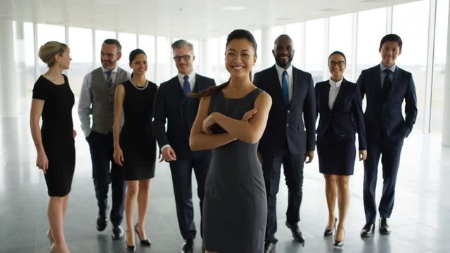 Portrait happy multiracial business team in large open plan office