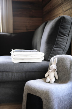 Trendy sofa and chair in gray wool fabric in an old renovated chalet for a cocooning and relaxing atmosphere