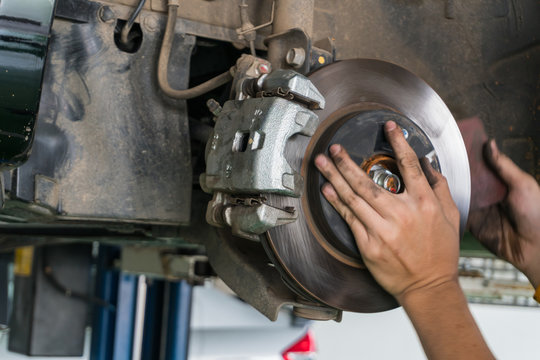 hands fixing car wheel hub disc brake