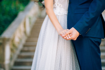 The newlyweds hold hands. Couple holding hands. Wedding in Montenegro.