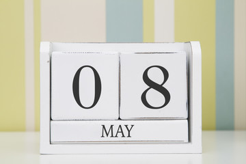 Cube shape calendar for MAY 8 on white table. 
