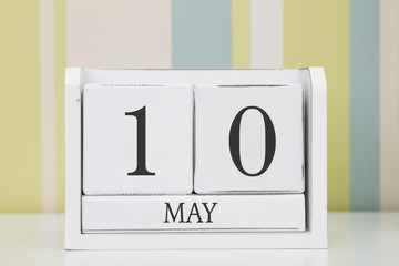 Cube shape calendar for MAY 10 on white table. 