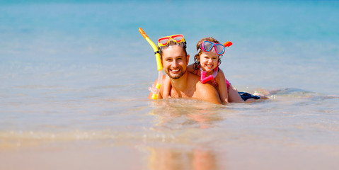 Happy family father and child wearing mask and laughing  on beach